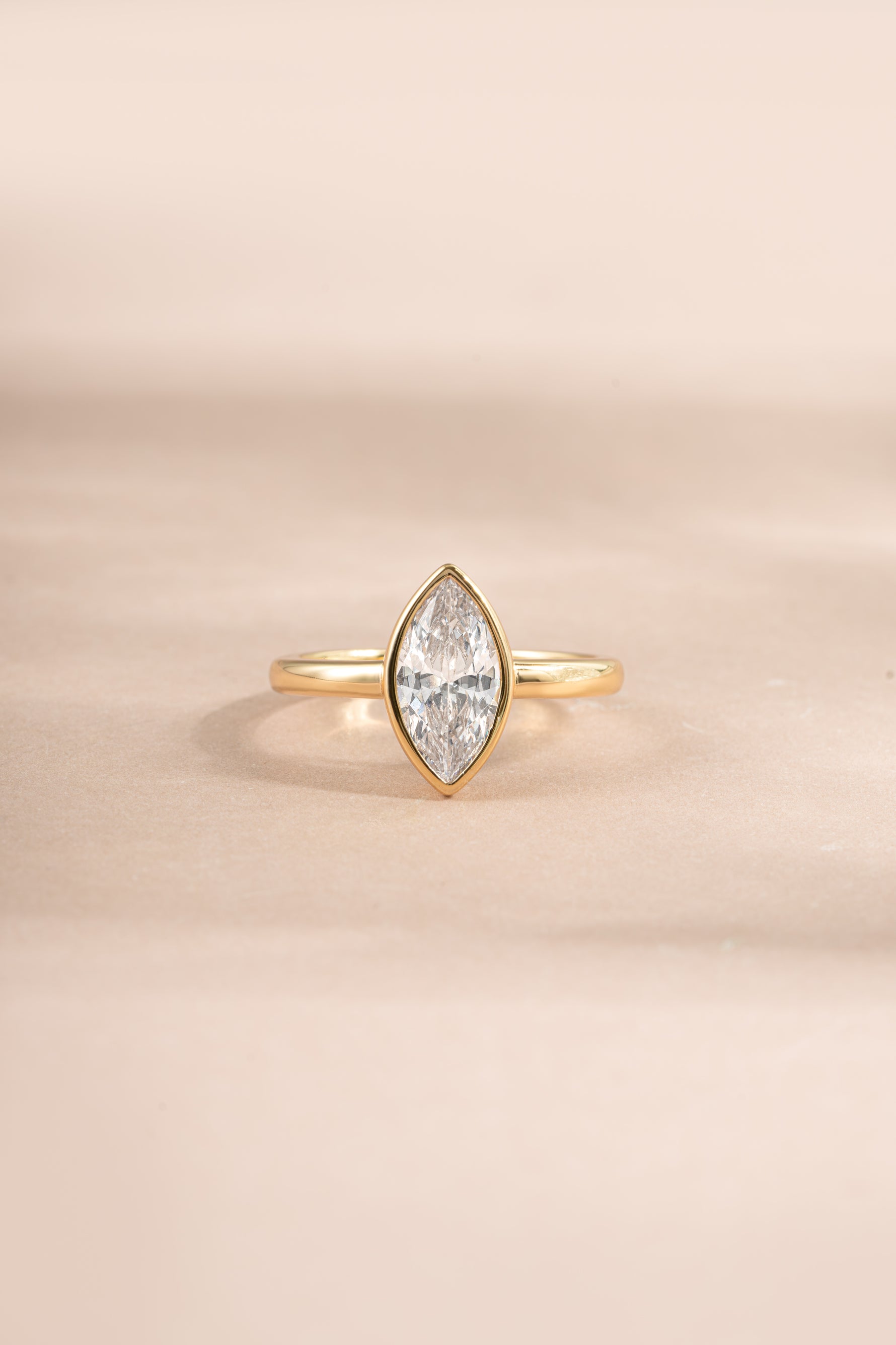 Gold Bezel Marquise Ring by Sami Jewels featuring a large marquise-shaped cubic zirconia gemstone.