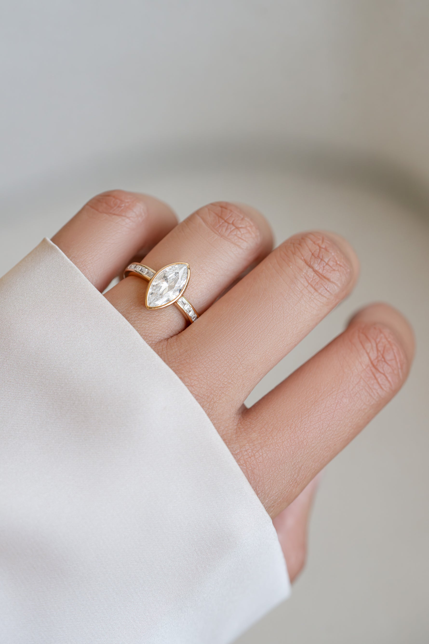 Gold Marquise Ring with Baguette Band by Sami Jewels worn on finger, showcasing elegant jewelry design.