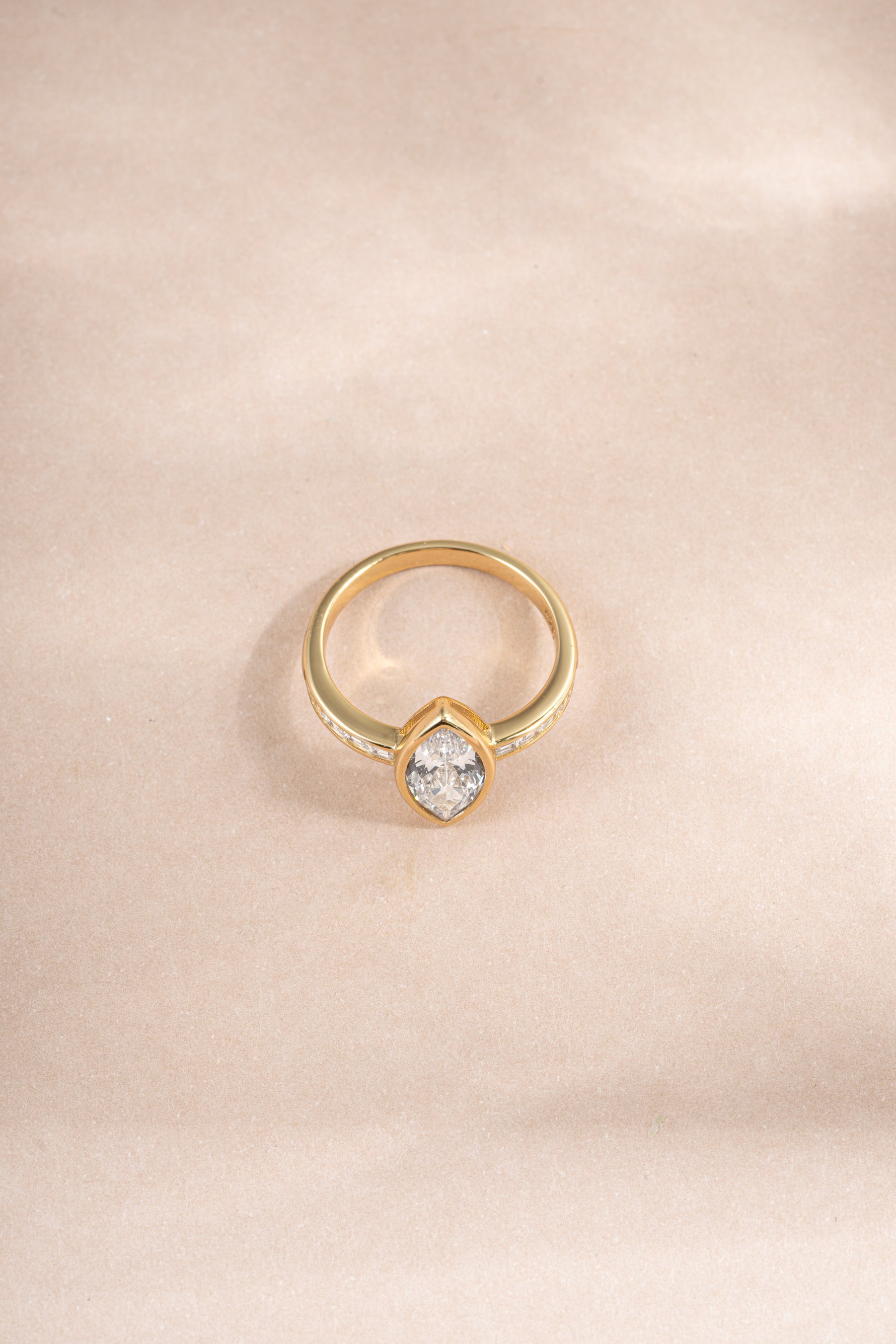 Gold marquise ring with baguette band, showcasing elegant diamond cuts, from Sami Jewels, viewed from the top.