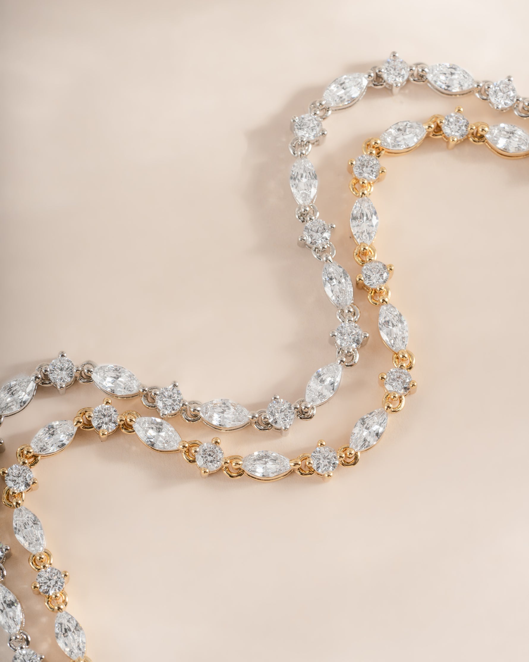 Sami Jewels gold and silver Marquise and Round Stone Diamond Tennis Bracelets displayed side by side.