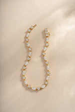 Gold Marquise and round stone diamond bracelet from Sami Jewels displayed in a flat lay.