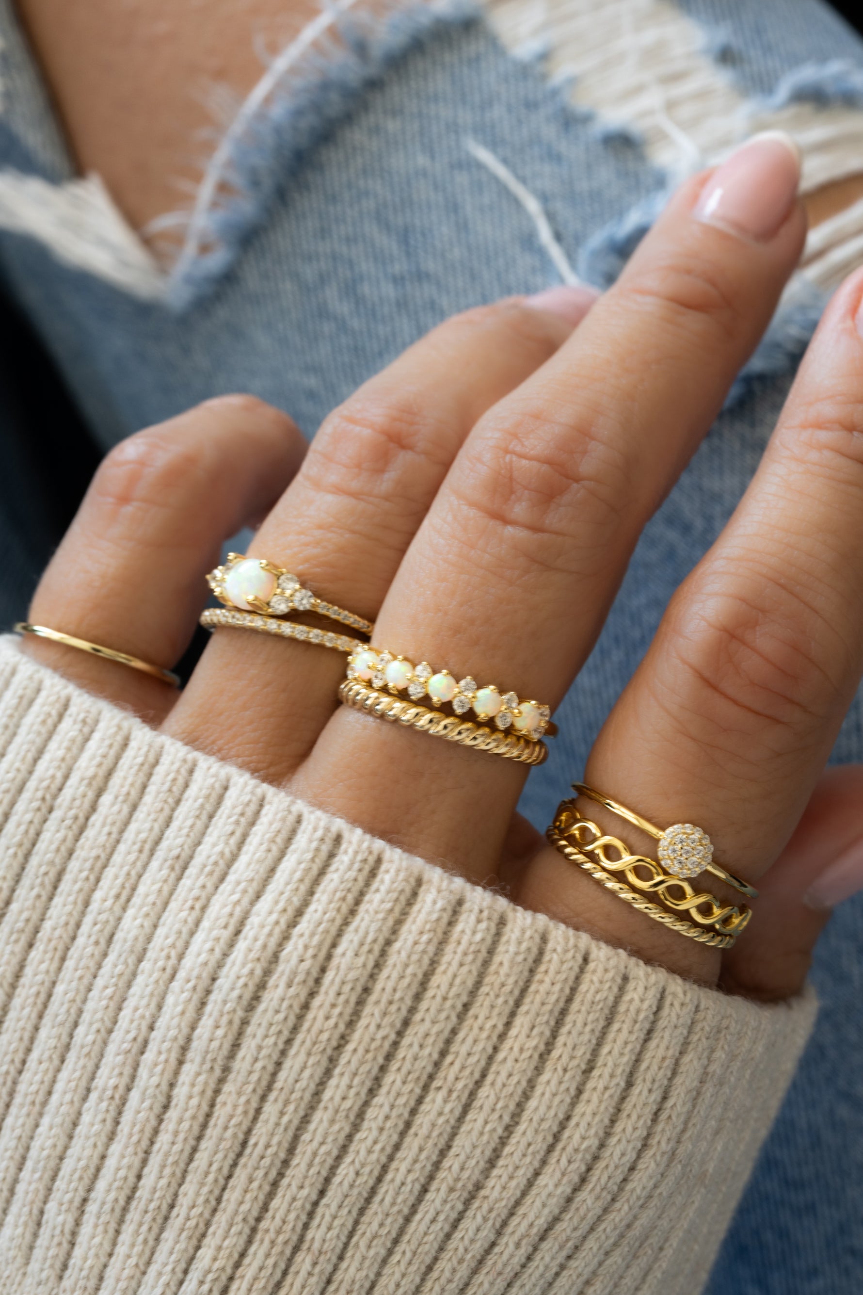 gold opal and cubic zirconia stacking ring stack on womens hand