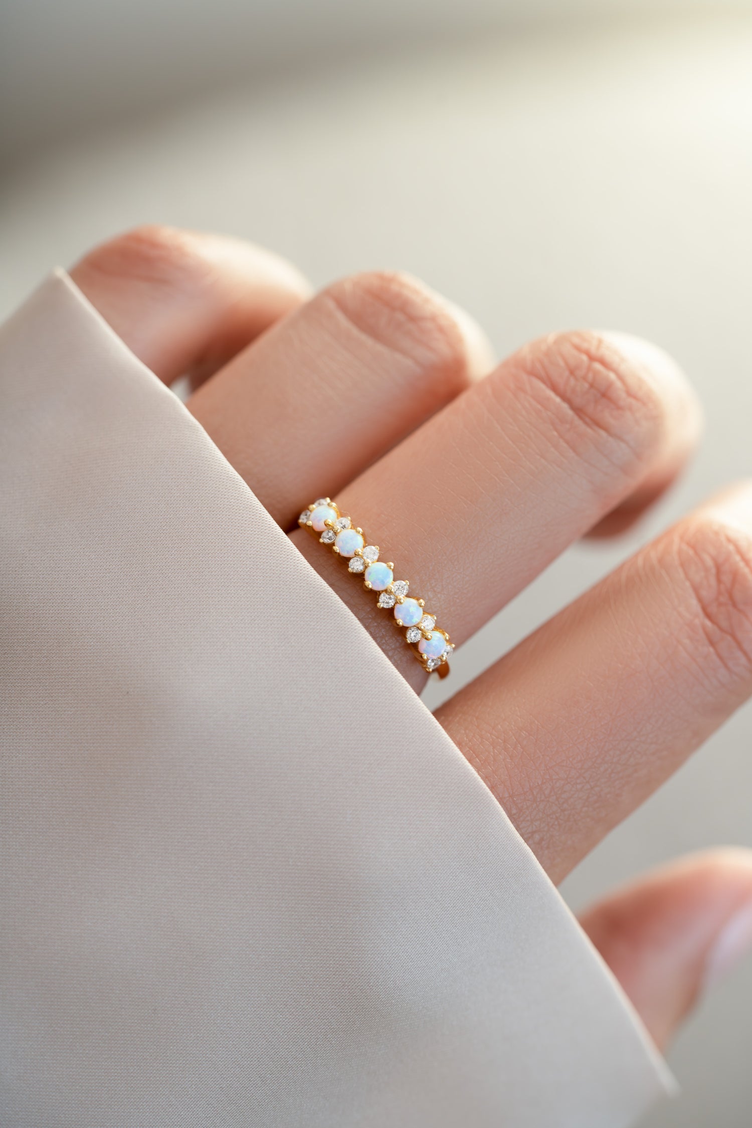 gold opal and cubic zirconia stacking ring on womens hand  