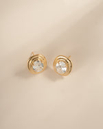 Angled view of gold oval bezel statement studs with their posts visible.