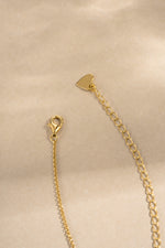 gold lobster clasp closure beaded pave necklace closeup neutral background