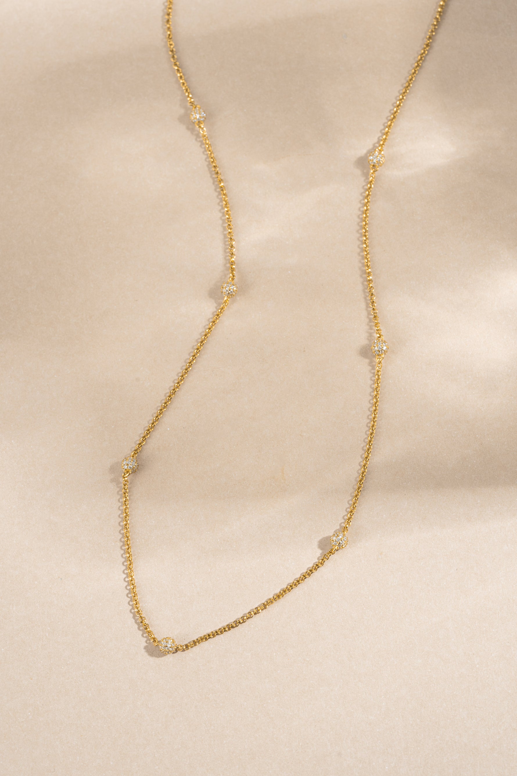 gold pave beaded necklace neutral background