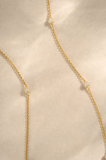 gold beaded pave necklace closeup  neutral background