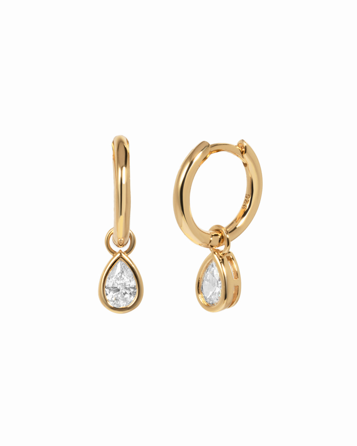 Pair of gold plated huggie earrings with removable pear-cut clear cubic zirconia charms on a white background.