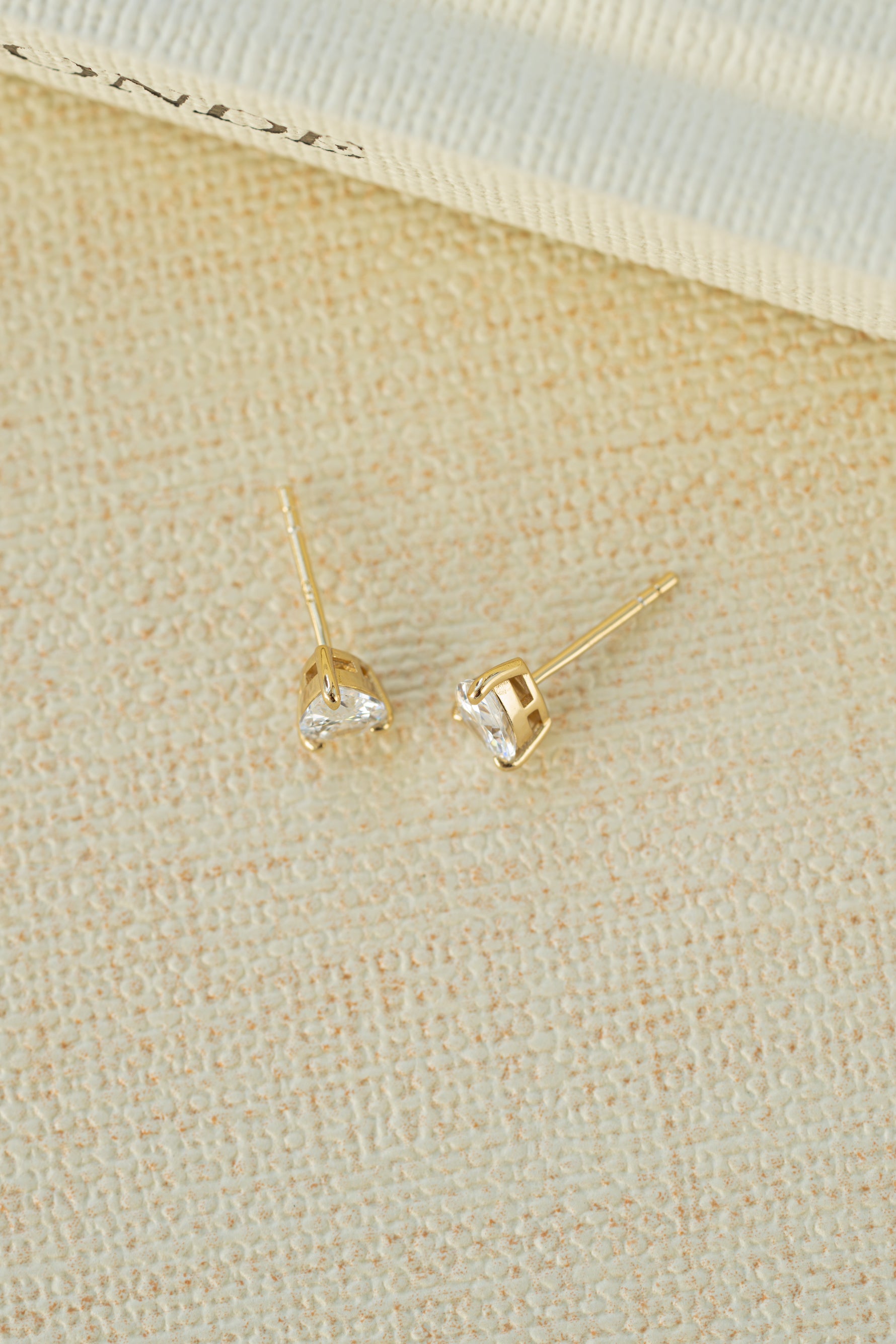 gold 5x7mm diamond pear stud earring profile neutral background 