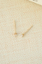 gold 2x3mm pear stud earring on neutral background
