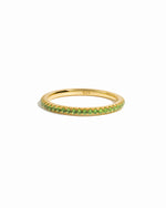 gold peridot birthstone eternity ring white background