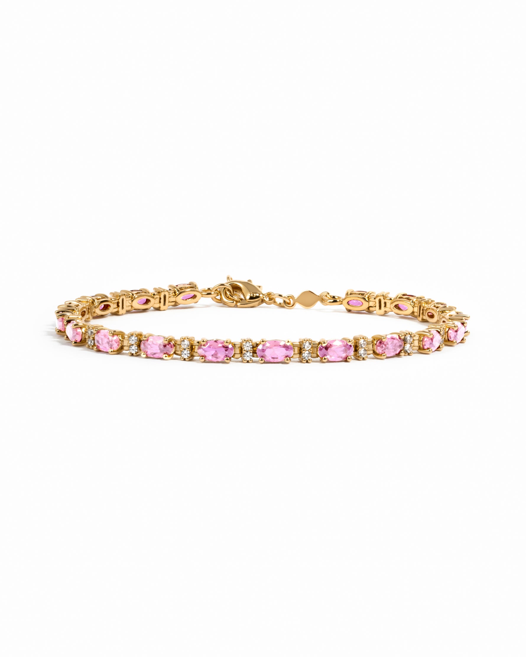 Gold tennis bracelet with oval-cut pink sapphires and diamond accents.