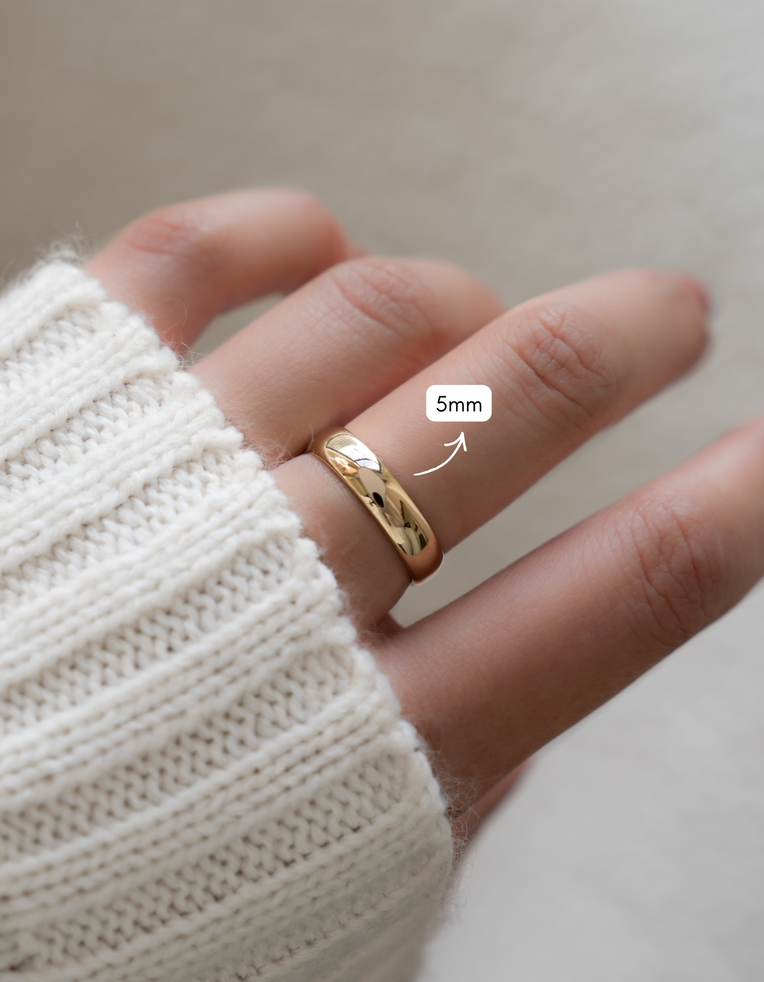 Gold 5mm plain band ring by Sami Jewels, showcasing a smooth, polished gold ring on a model's hand.