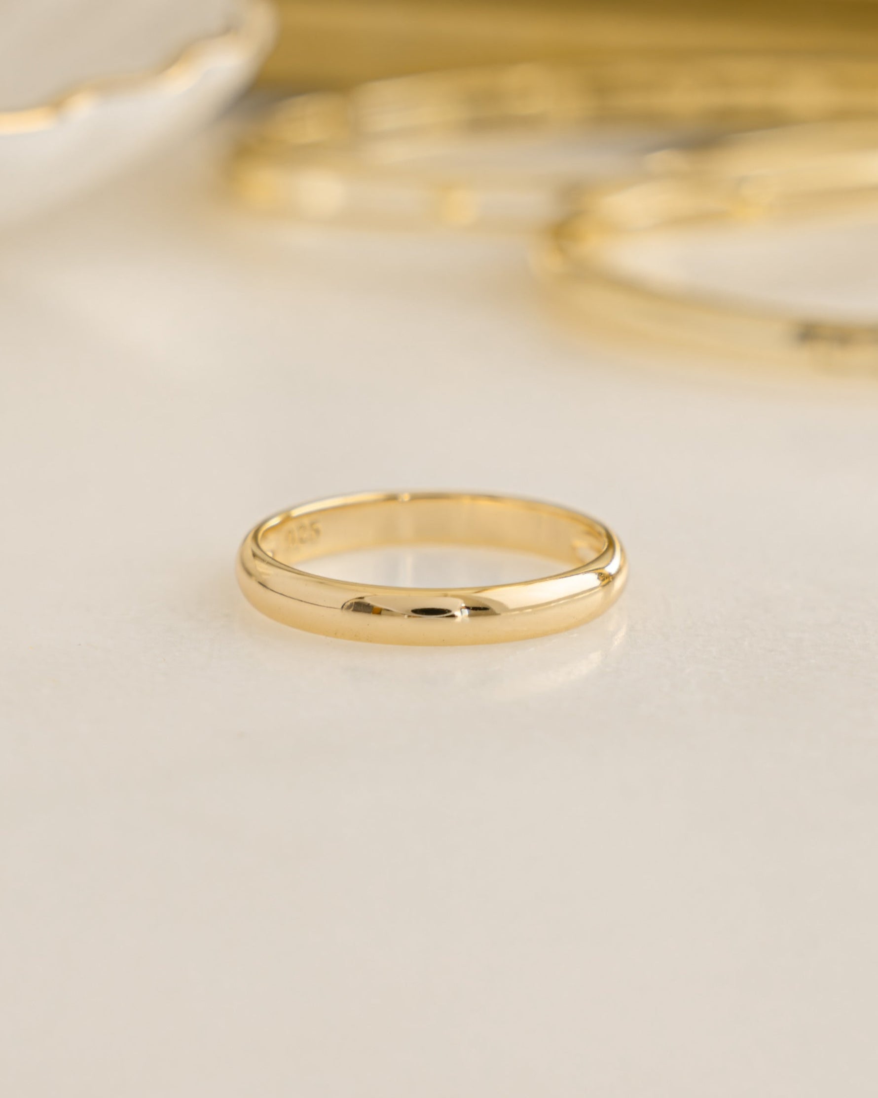 Gold 3mm plain band ring by Sami Jewels, showing a simple, smooth gold stacking ring on a neutral background.