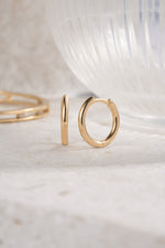 gold 11mm minimalist hoop earrings neutral background