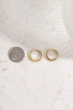 gold plated 11mm studded huggie being compared to a dime size