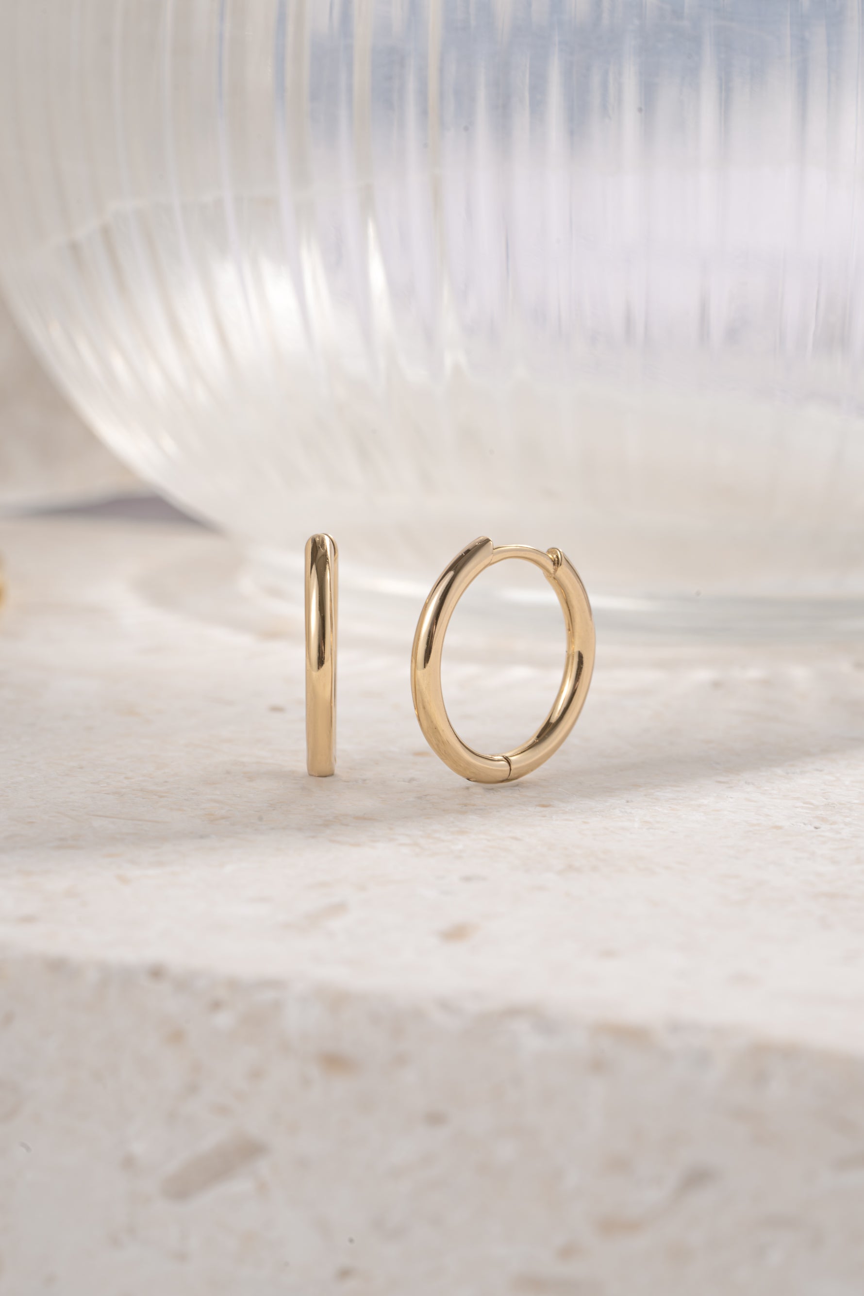 gold 13mm minimalist hoop earrings on a neutral background 