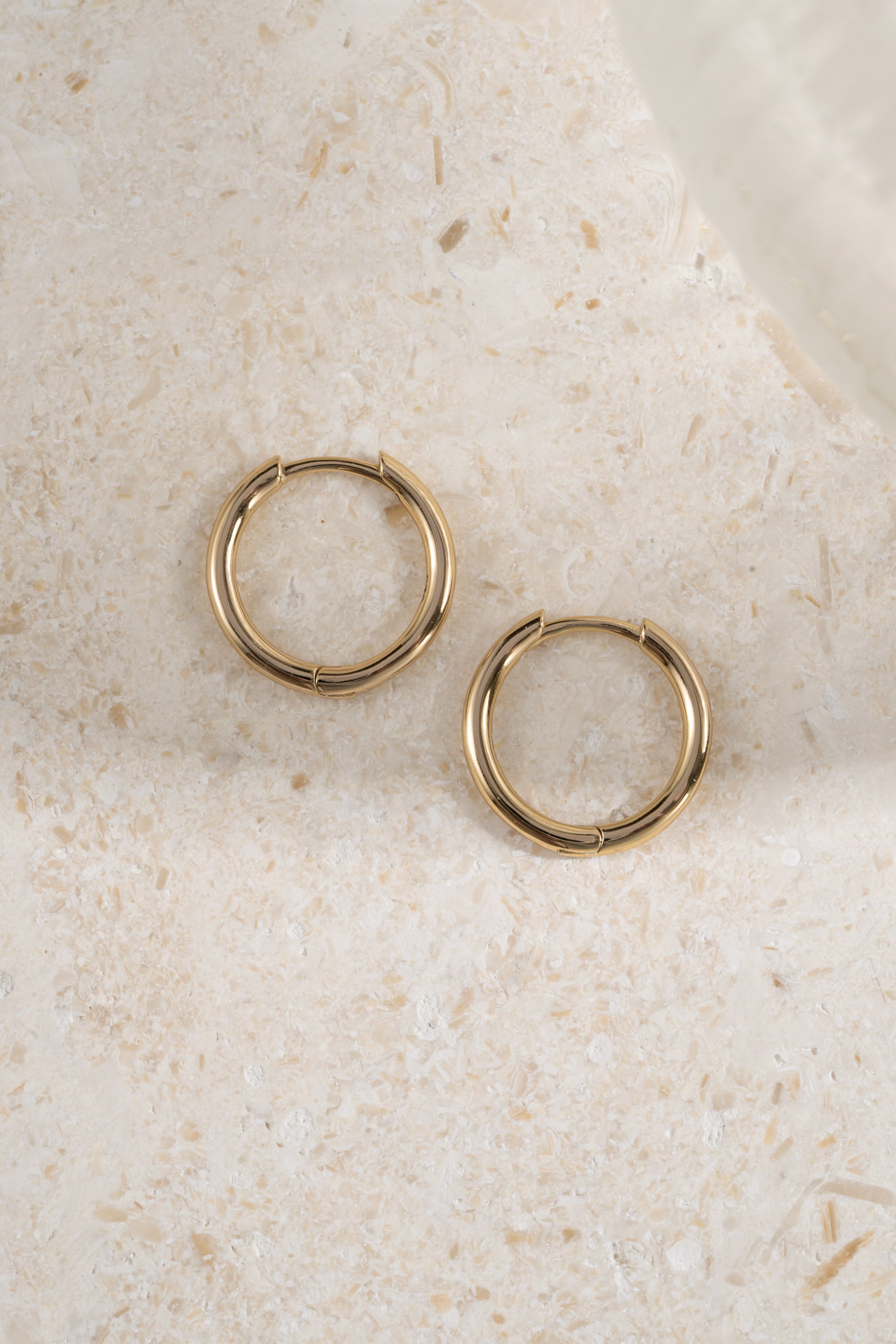 gold 13mm minimalist hoop earrings profile view on a neutral background 