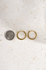 gold plated 13mm studded huggie hoop being compared to a dime