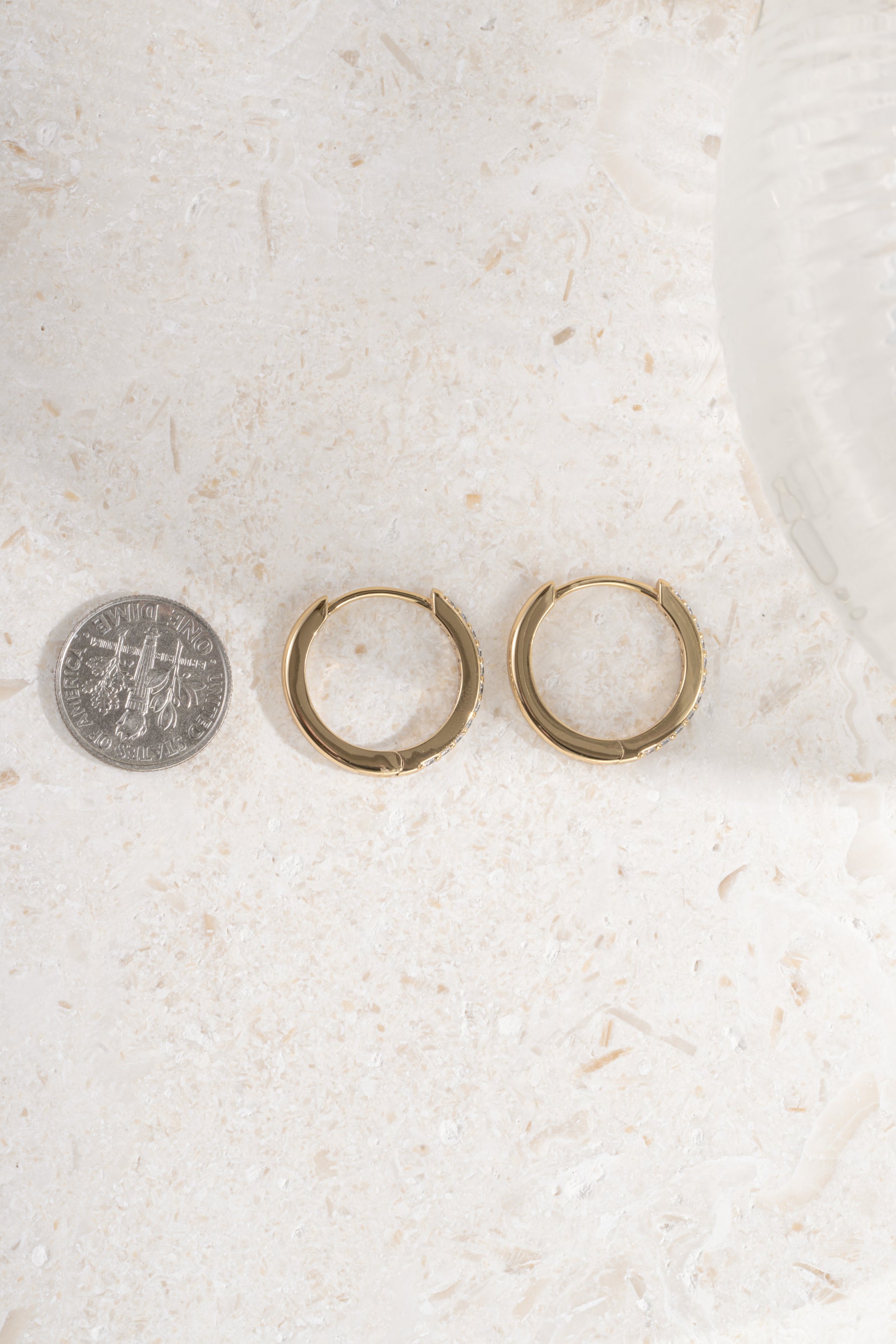 gold plated 16mm studded huggie being compared to a dime size