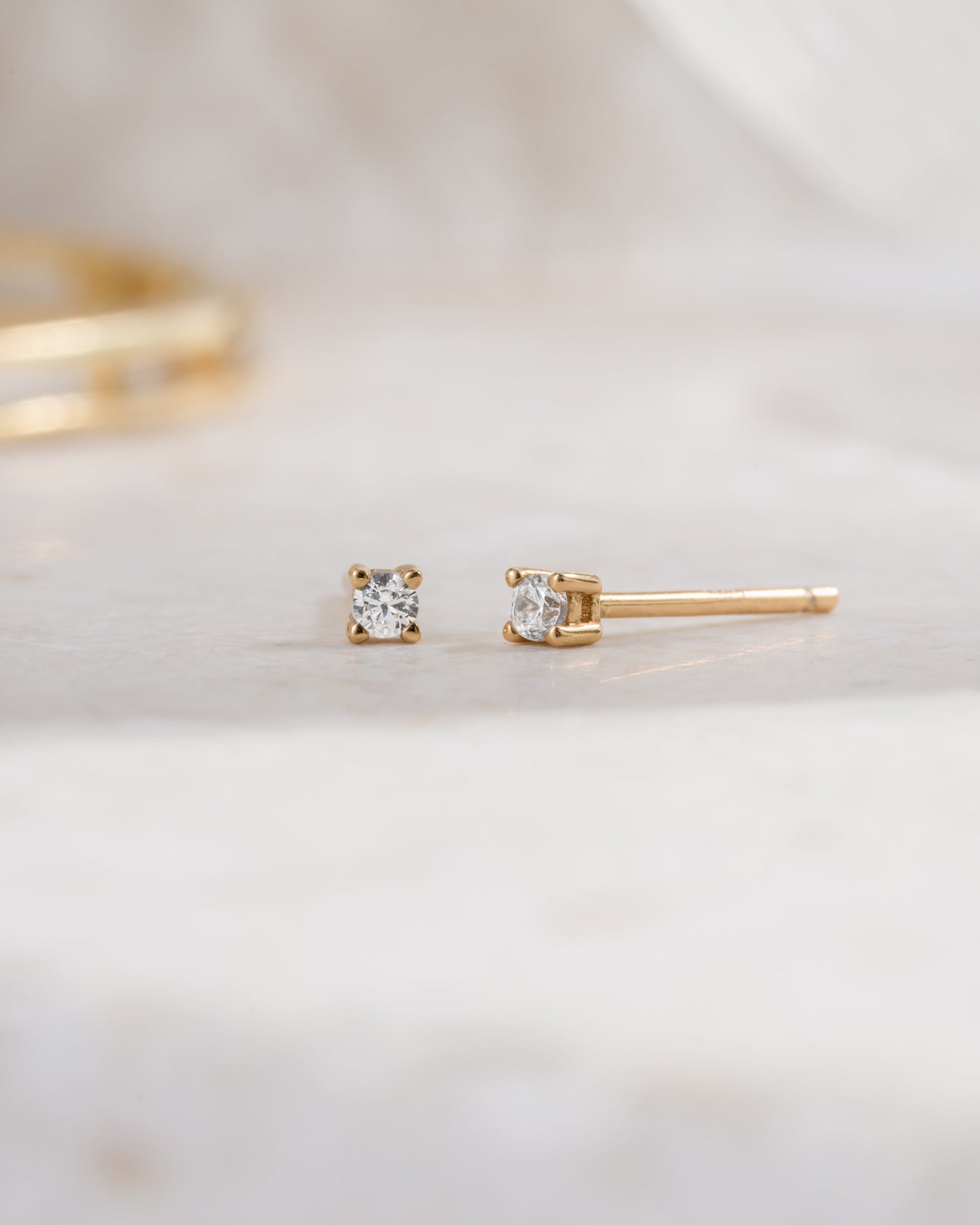 gold plated 2mm diamond solitaire stud earring side view white background