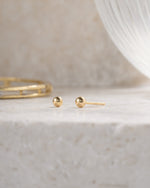 gold 3mm ball stud earring on a neutral background