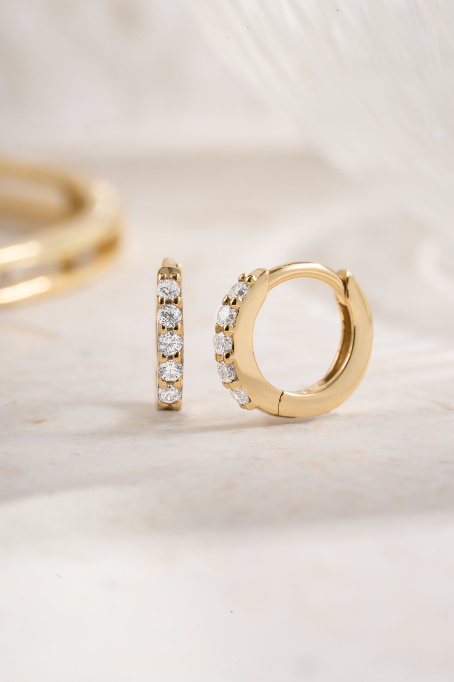 Gold plated 7mm studded huggie earrings with cubic zirconia angled view