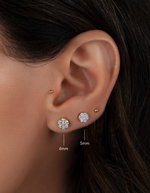 Model wearing round diamond gold stud earrings in 6mm and 5mm, paired with a classic gold ball stud. 