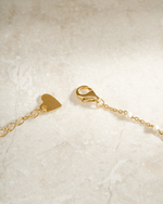 gold cream enamel beaded necklace closure clasp neutral background