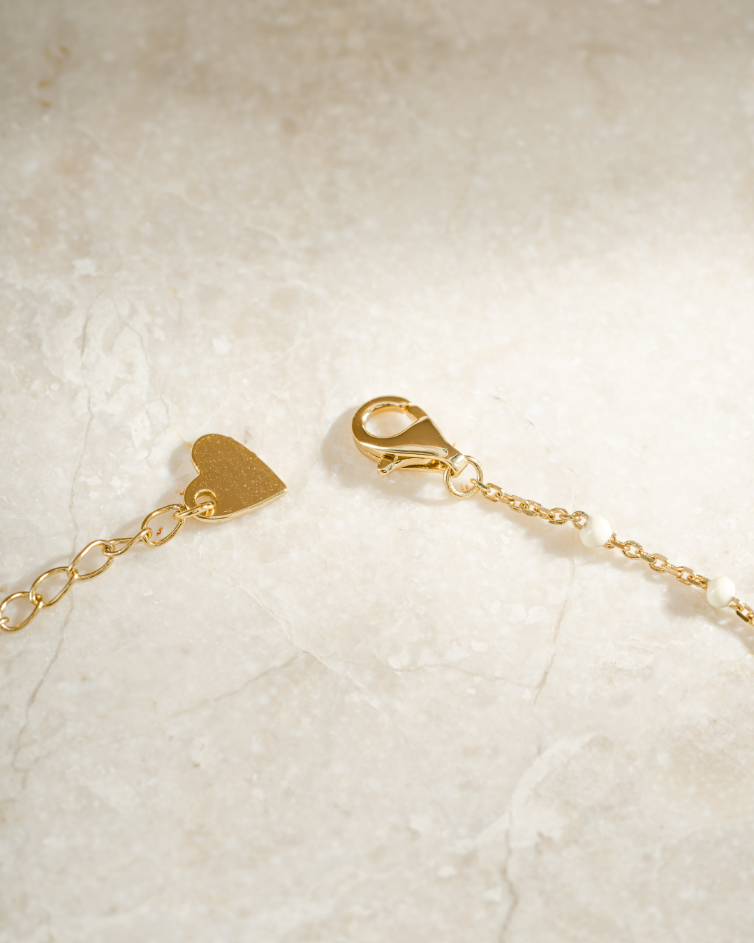 gold cream enamel beaded necklace closure clasp neutral background