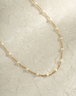 gold cream enamel beaded dainty necklace neutral background