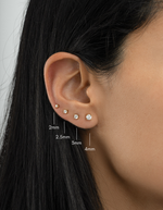 Gold plated diamond solitaire stud earrings on womens ear in sizes ranging from 2mm, 2,5mm, 3mm and 4mm 