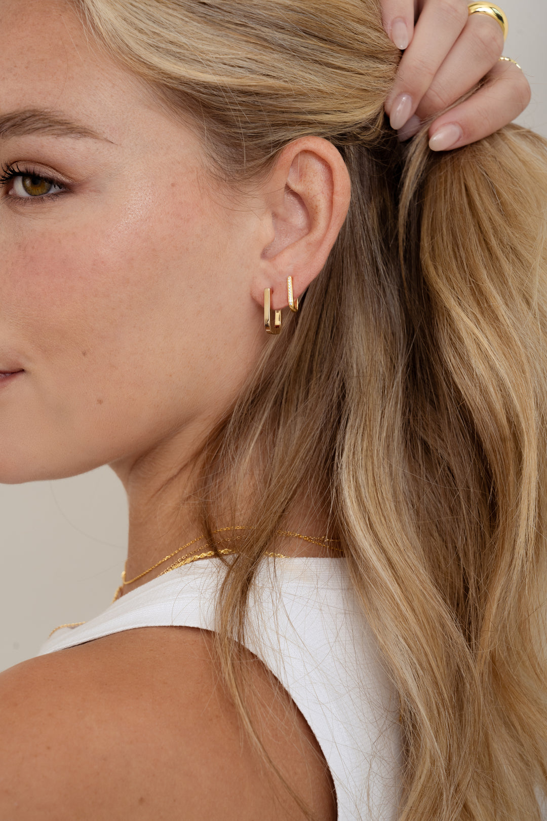 gold plated square hoop earrings on womens ear