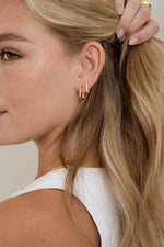 gold plated square hoop earrings on womens ear
