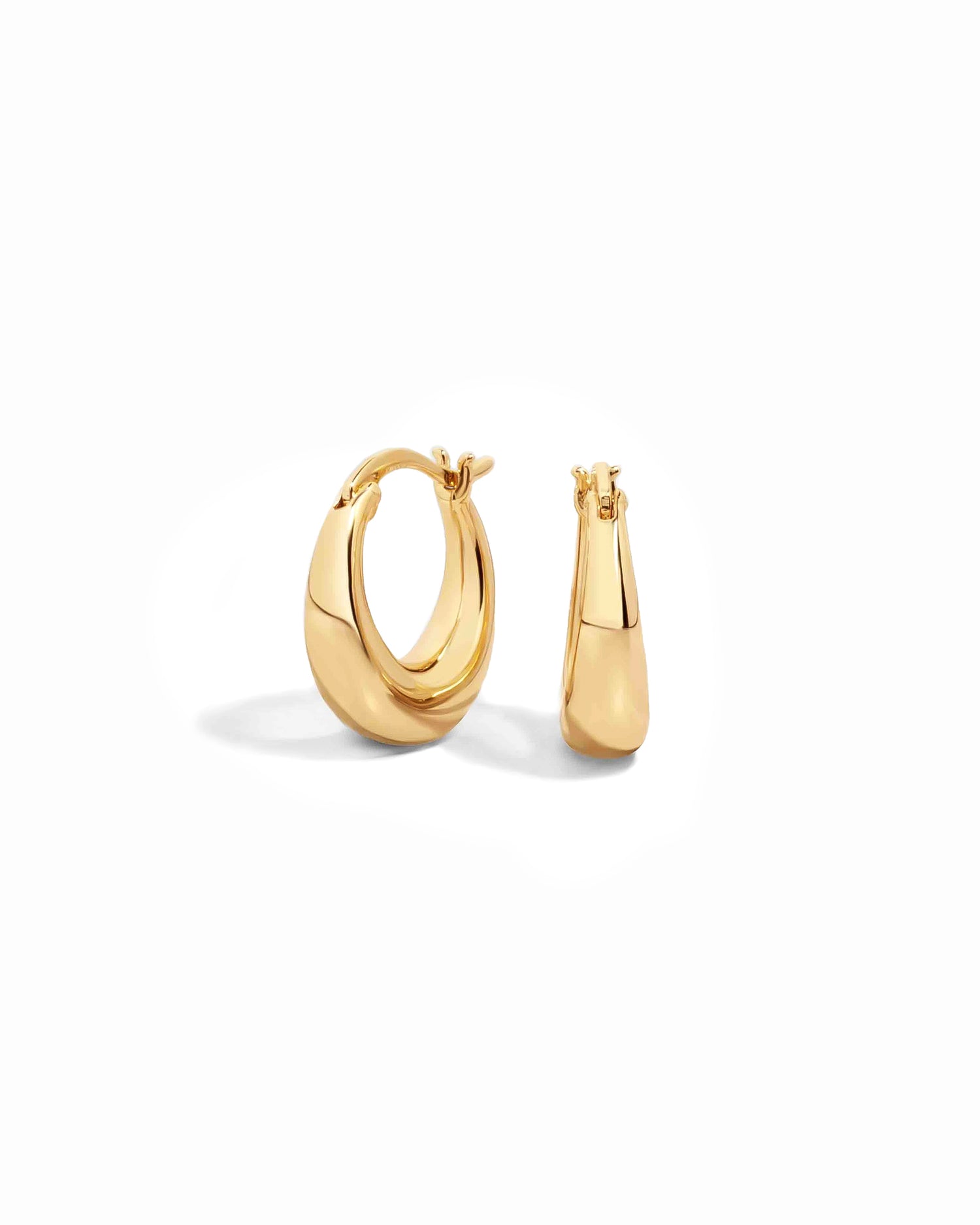 Gold chunky hoop earrings on a white background