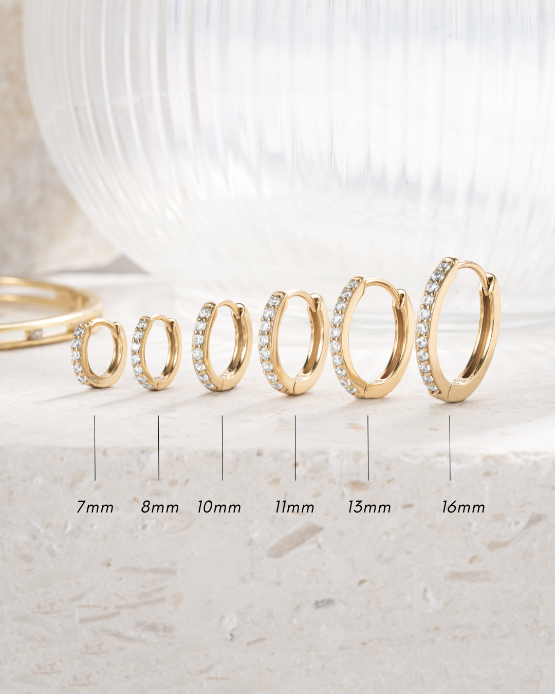 gold plated diamond studded huggies in sizes 7mm, 8mm, 10mm, 11mm, 13mm and 16mm, neutral background