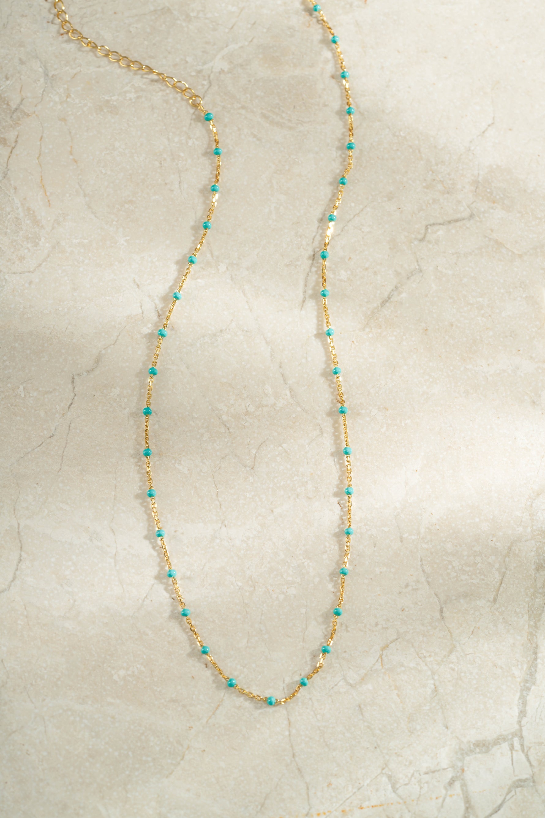gold turquoise enamel beaded necklace neutral background