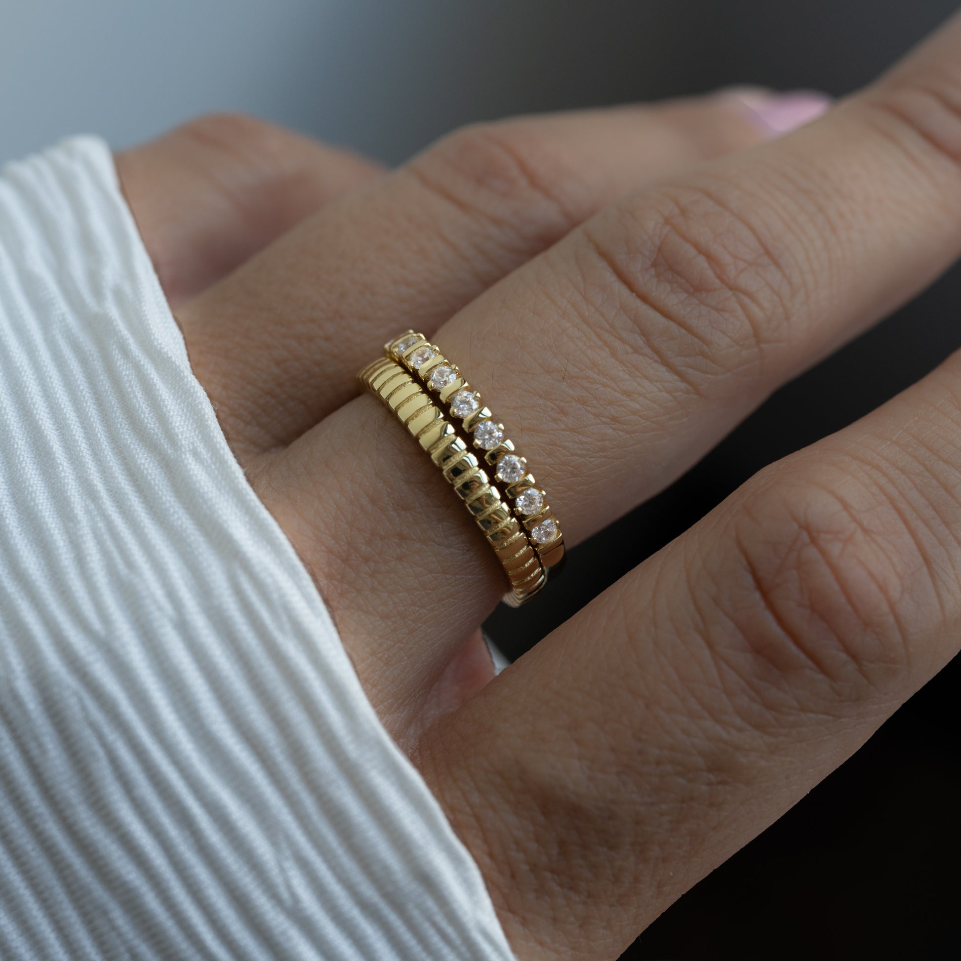 model wearing gold textured ring and cz fluted ring stack