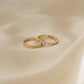 Tiny gold ring set with cz diamonds plated in 14k gold, showcased on tan silk