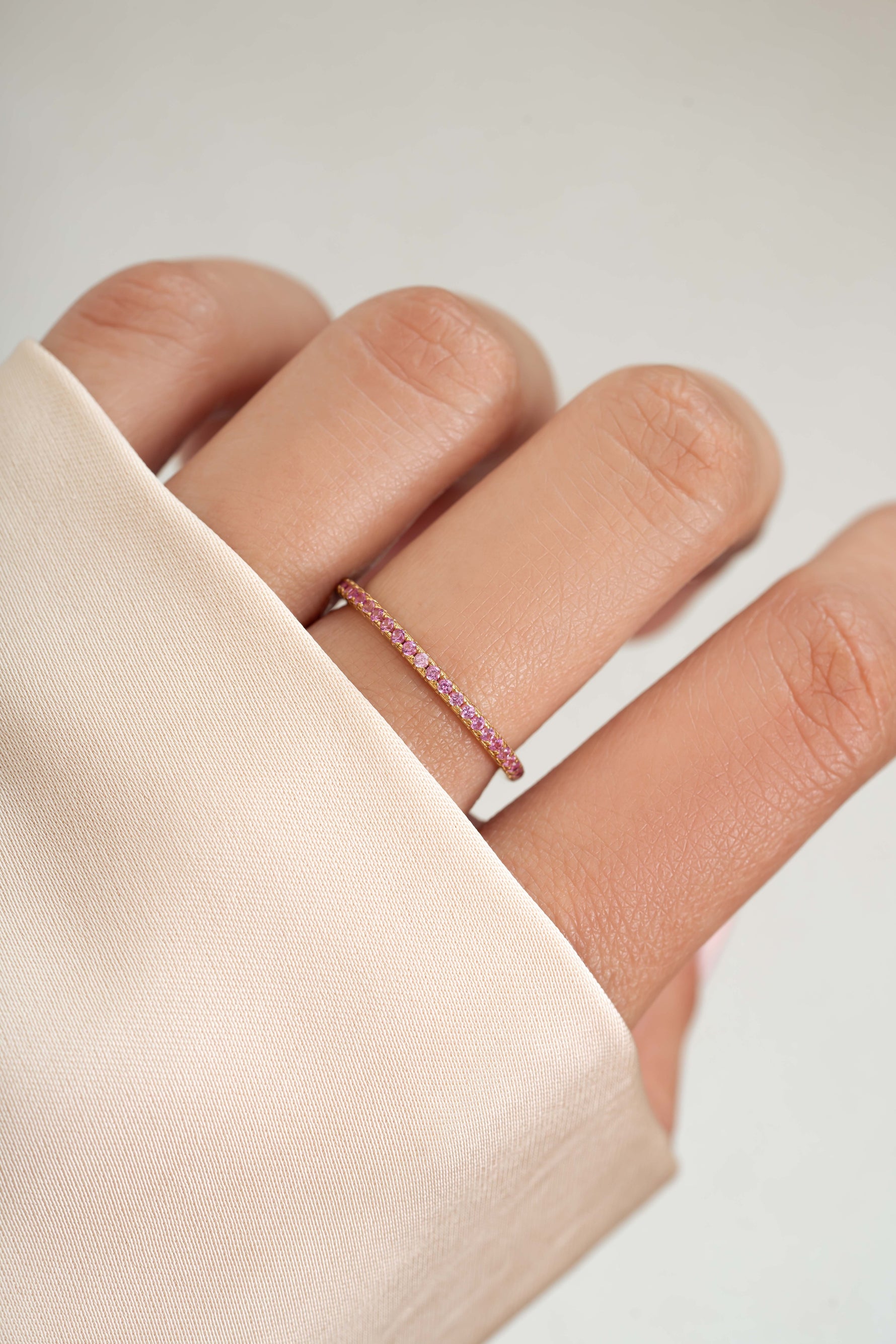 gold rose October birthstone eternity ring on womens hand