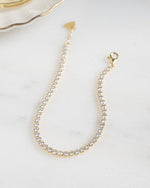 gold diamond round tennis bracelet on closeup 