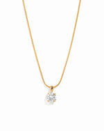 Gold round solitaire CZ pendant necklace on a white background.