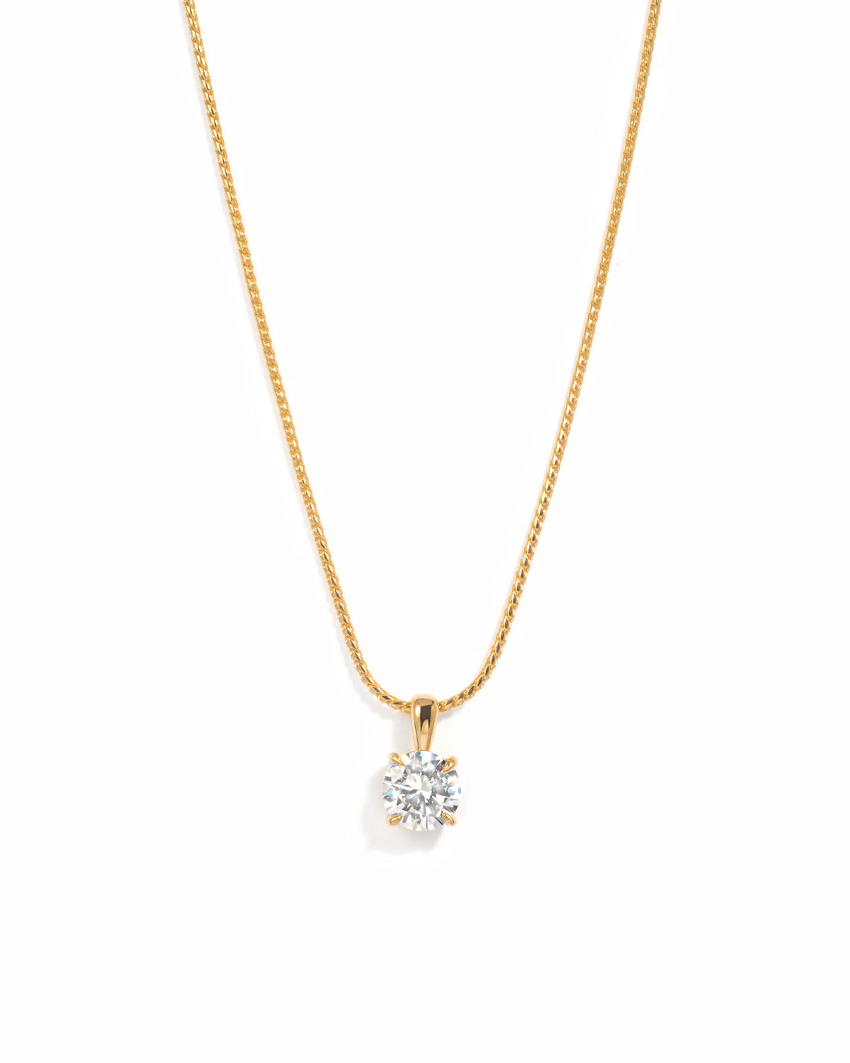 Gold round solitaire CZ pendant necklace on a white background.