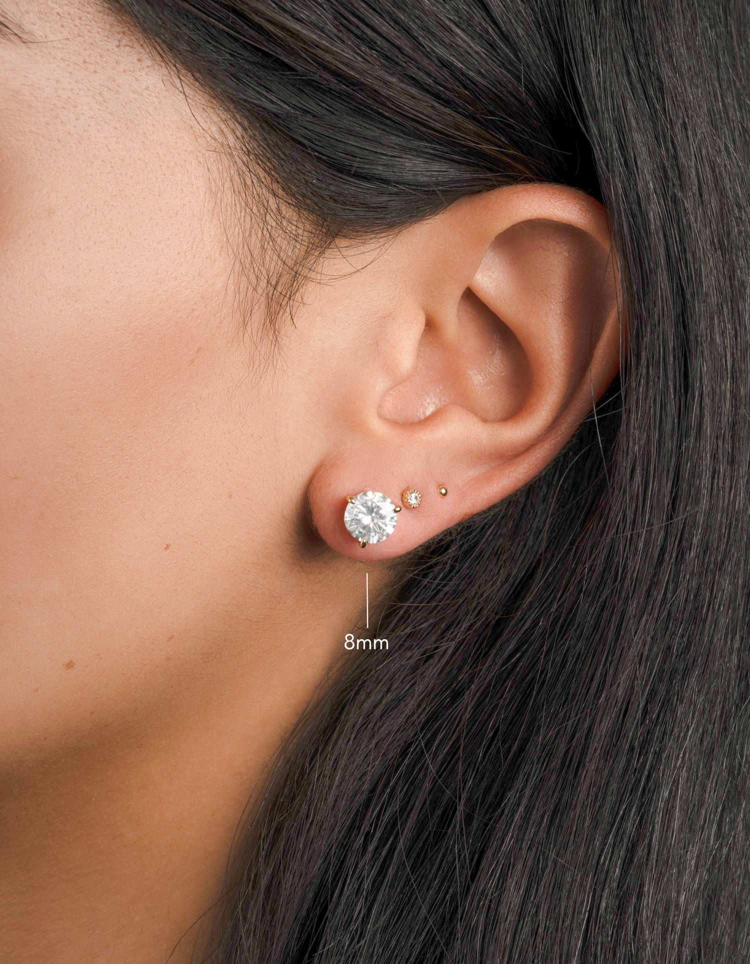 gold round diamond stud solitaire earrings on womens ear
