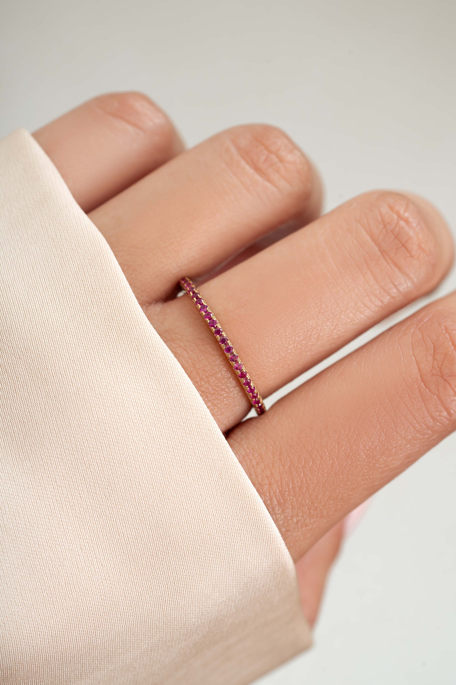 gold ruby birthstone eternity ring on womens hand