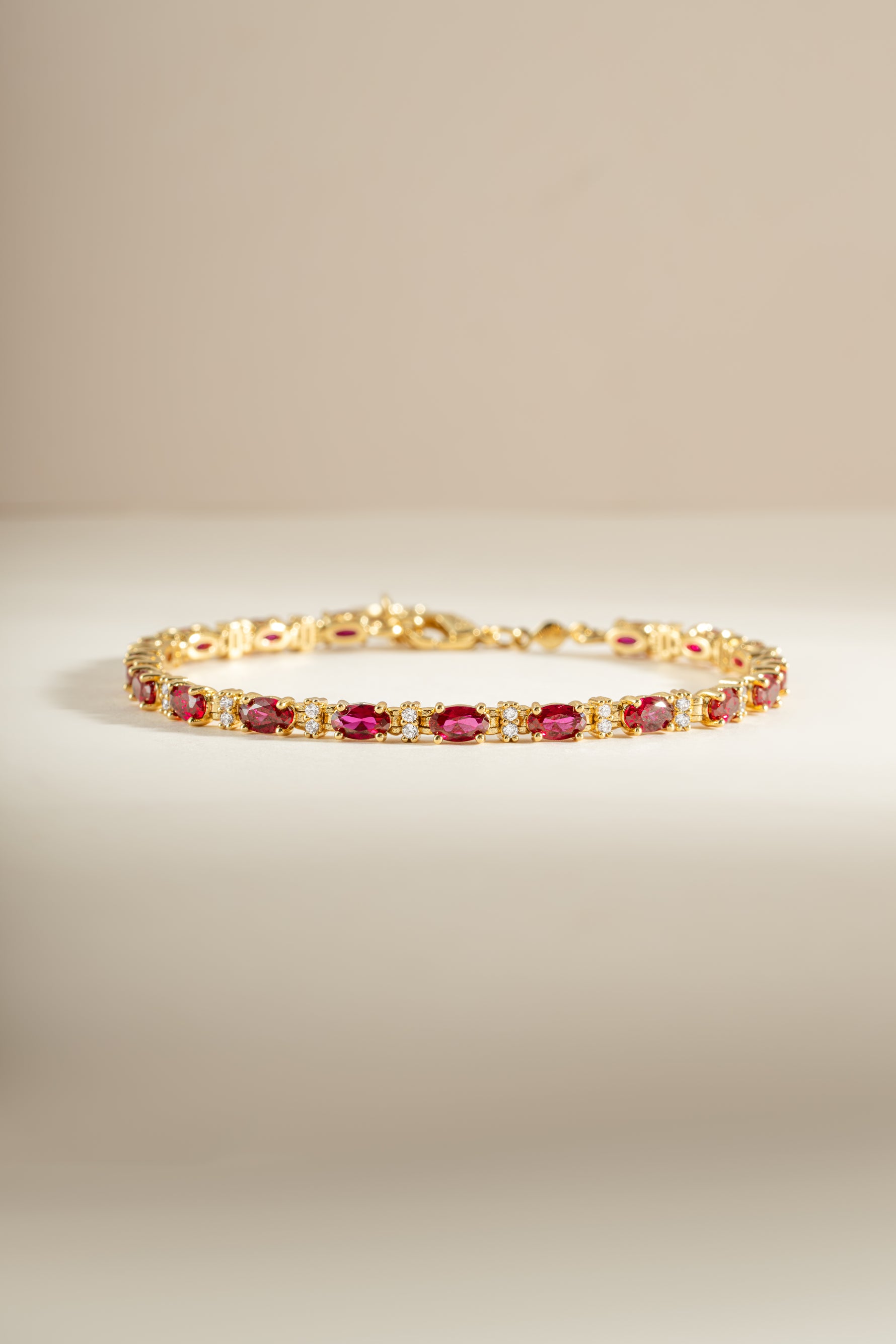 Gold Ruby Tennis Bracelet by Sami Jewels featuring dainty ruby stones and sparkling diamonds on a delicate bracelet.