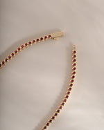 Gold Ruby Bezel Tennis Necklace by Sami Jewels with dainty design and box clasp, featuring sparkling rubies along a sleek gold chain.