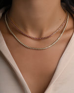 Gold layered tennis necklace with ruby bezel and diamond accents, modeled on a woman, by Sami Jewels.