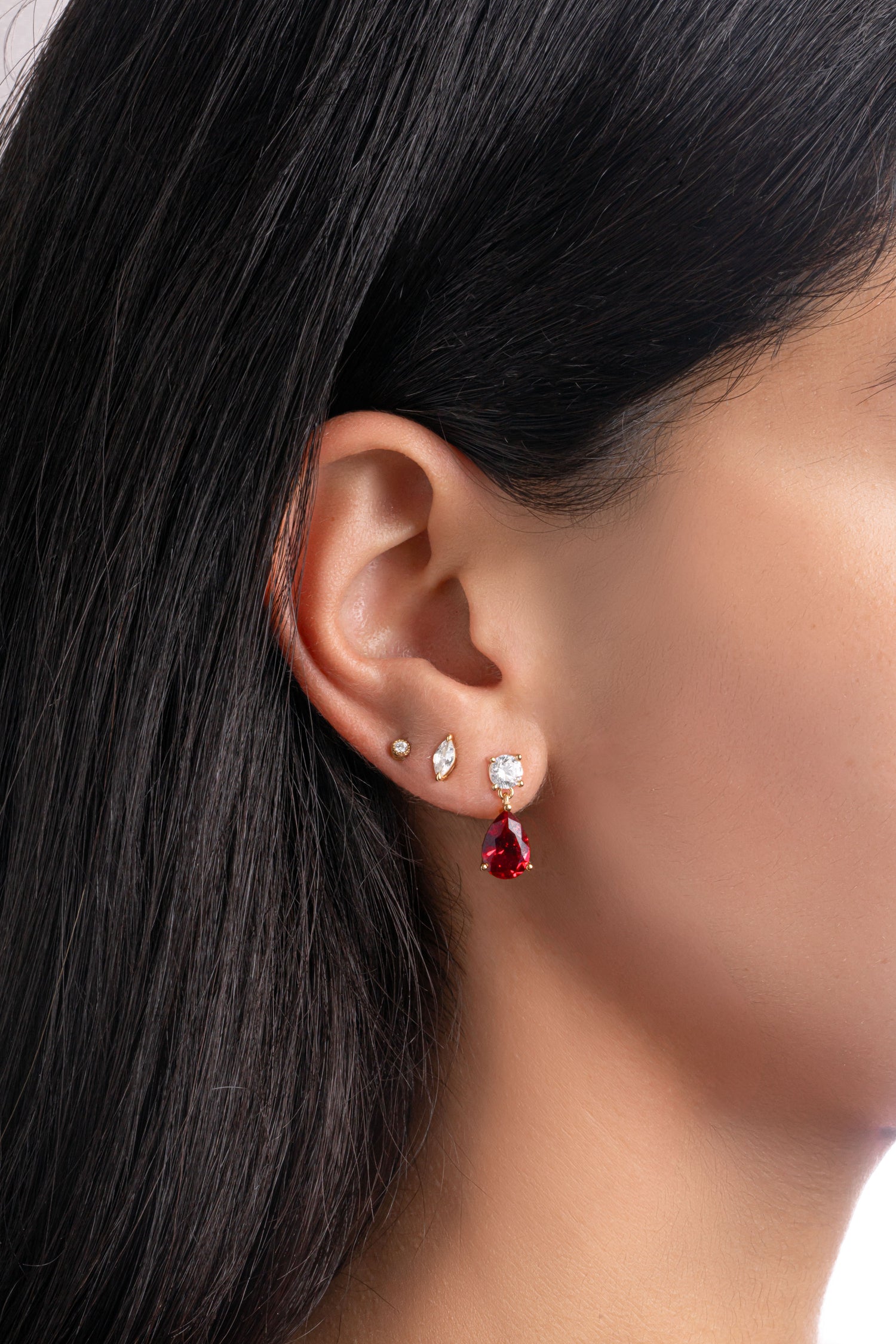 Gold Ruby Pear Drop Earrings by Sami Jewels featuring pear-shaped ruby dangles on a model.