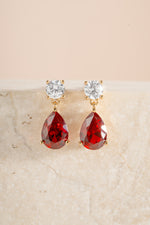 Gold ruby pear drop earrings by Sami Jewels featuring diamond stud details and elegant drop design.